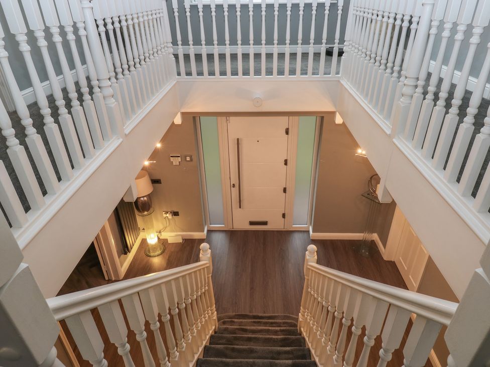 A hallway with stairs and a front door at 20 Overland Crescent in Apperley Bridge