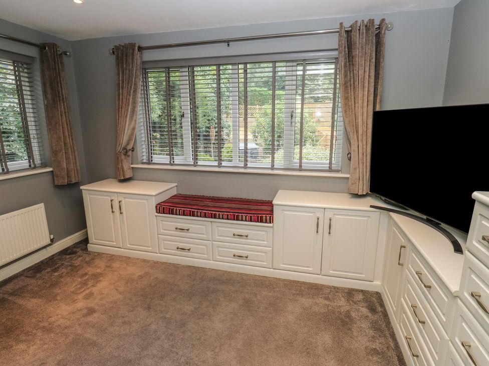 A living room with a storage cabinet and television at 20 Overland Crescent in Apperley Bridge