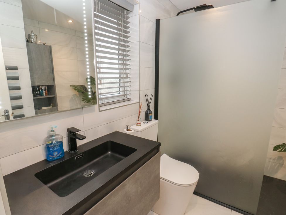 A bathroom with a sink, toilet, and shower at 20 Overland Crescent in Apperley Bridge