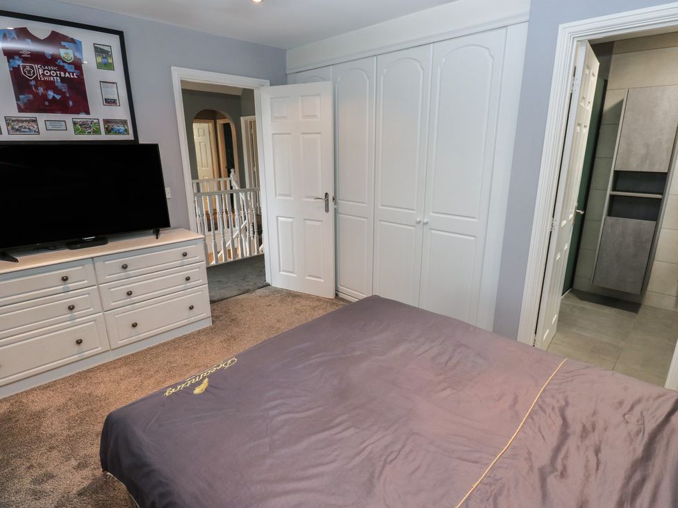 A bedroom with a television and dresser at 20 Overland Crescent in Apperley Bridge