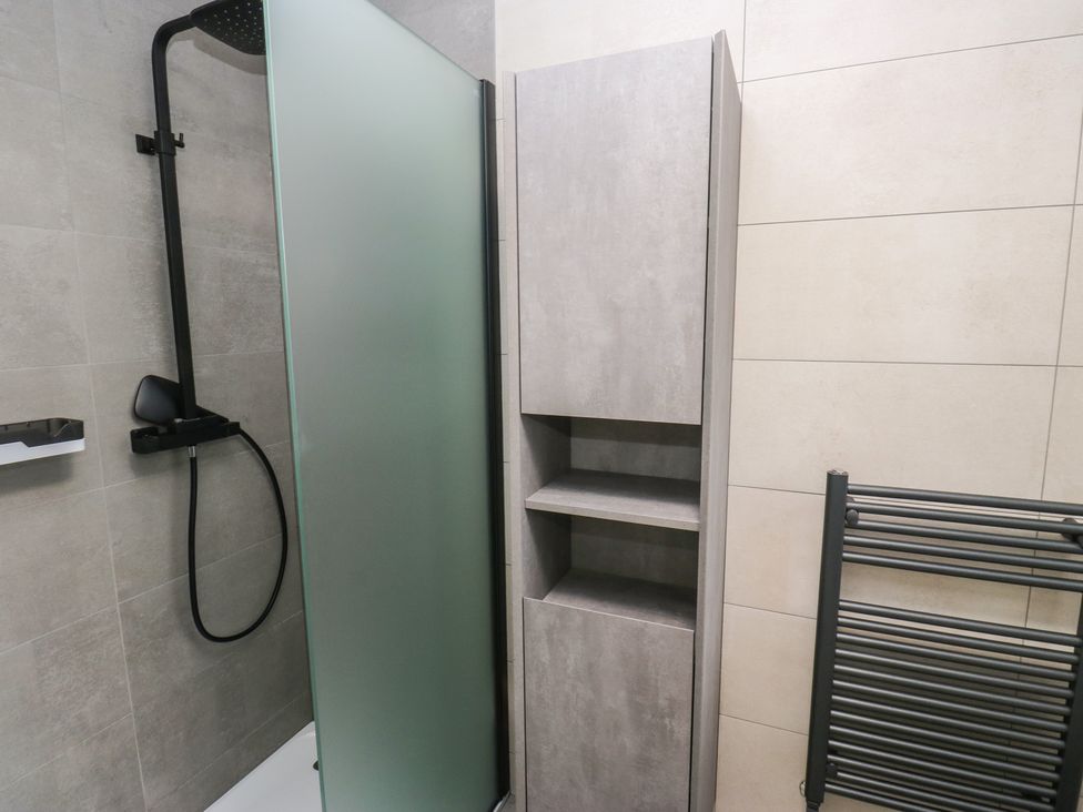 A bathroom with a shower and storage cabinet at 20 Overland Crescent Apperley Bridge