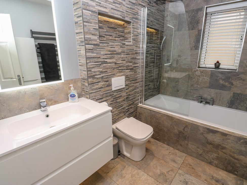 A bathroom with a sink, toilet, shower, and bathtub at 20 Overland Crescent in Apperley Bridge