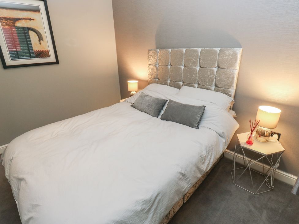 A bedroom with a bed and bedside table at 20 Overland Crescent in Apperley Bridge