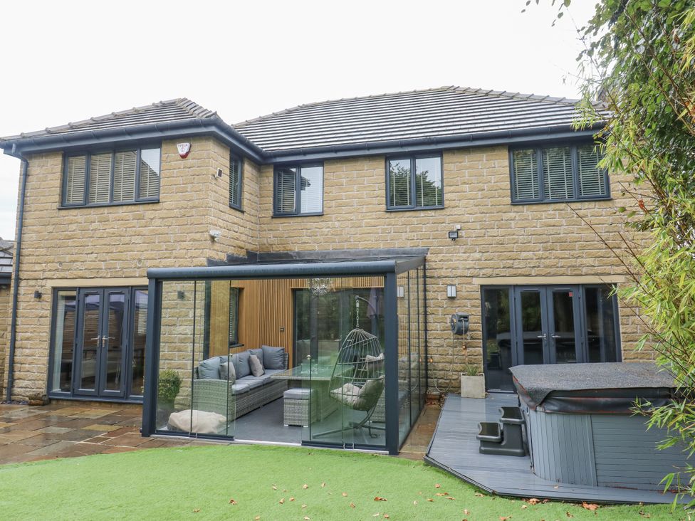 A glass extension with seating area and hot tub at Corriegale in Apperley Bridge