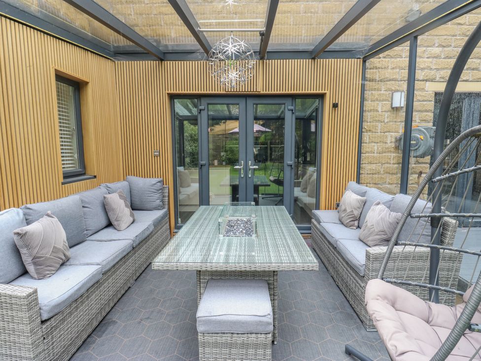 A conservatory with seating and a table at Corriegale in Apperley Bridge