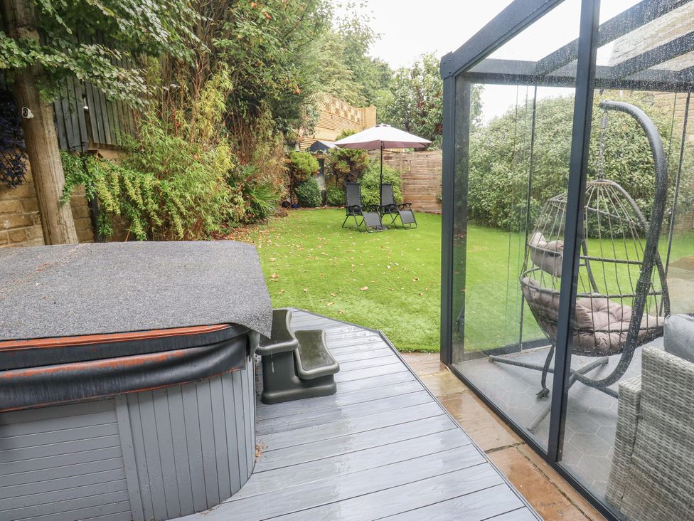 A garden with a hot tub and lounge chairs at Corriegale in Apperley Bridge