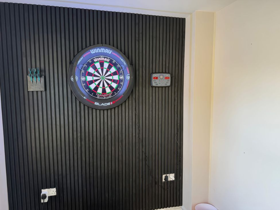 A dartboard with scoreboard and darts at Corriegale in Apperley Bridge