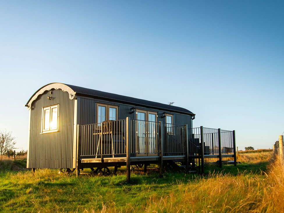 A shepherd's hut with a deck and handrails at Head For the Hills Glamping - Skylark Shepherd's Hut