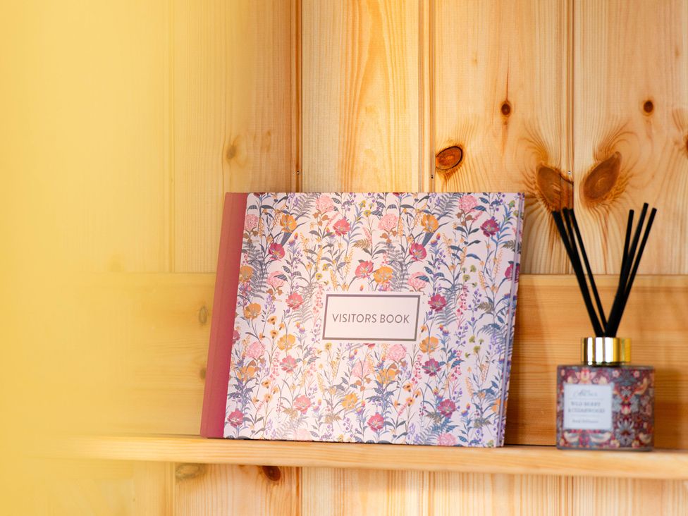 A visitors book and reed diffuser on a shelf at Head For the Hills Glamping - Skylark Shepherd's Hut