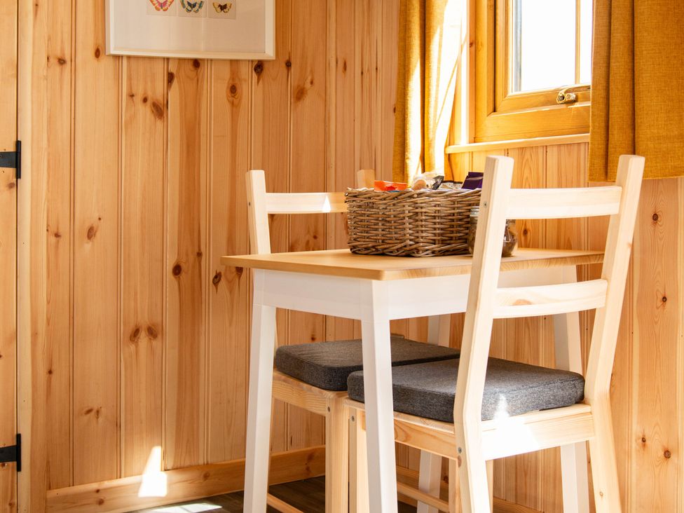 A dining area with a table and chairs at Head For the Hills Glamping - Skylark Shepherd's Hut