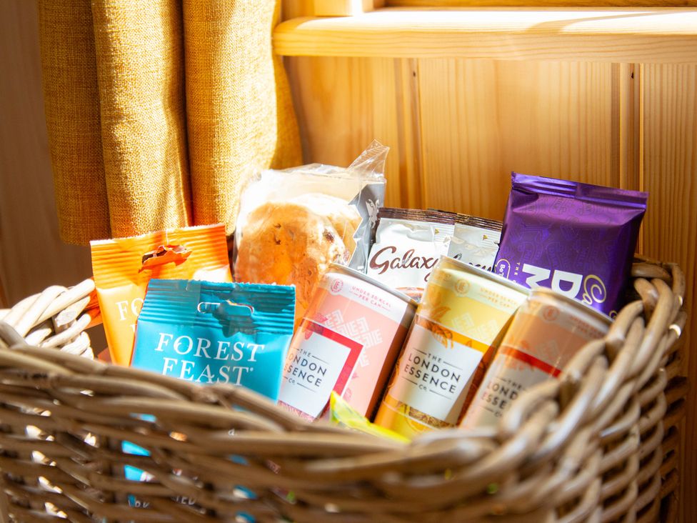 A basket filled with snacks and drinks at Head For the Hills Glamping - Skylark Shepherd's Hut