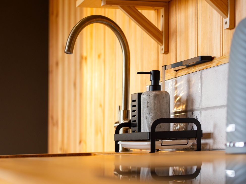 A kitchen sink with a faucet and soap dispenser at Head For the Hills Glamping - Skylark Shepherd's Hut