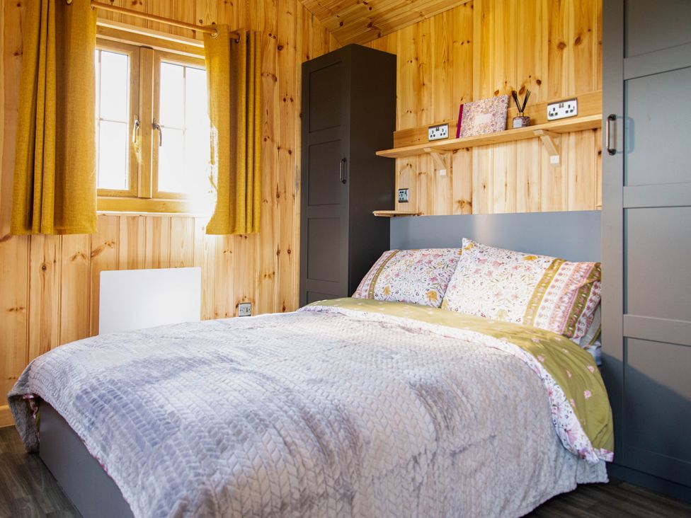 A bedroom with a bed and a window at Head For the Hills Glamping - Skylark Shepherd's Hut