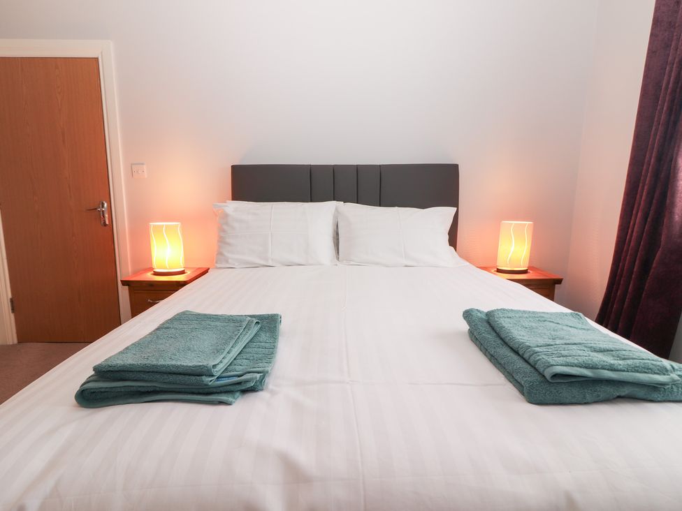 A bedroom with a bed and lamps on bedside tables at 1 Windermere in Kinvarra