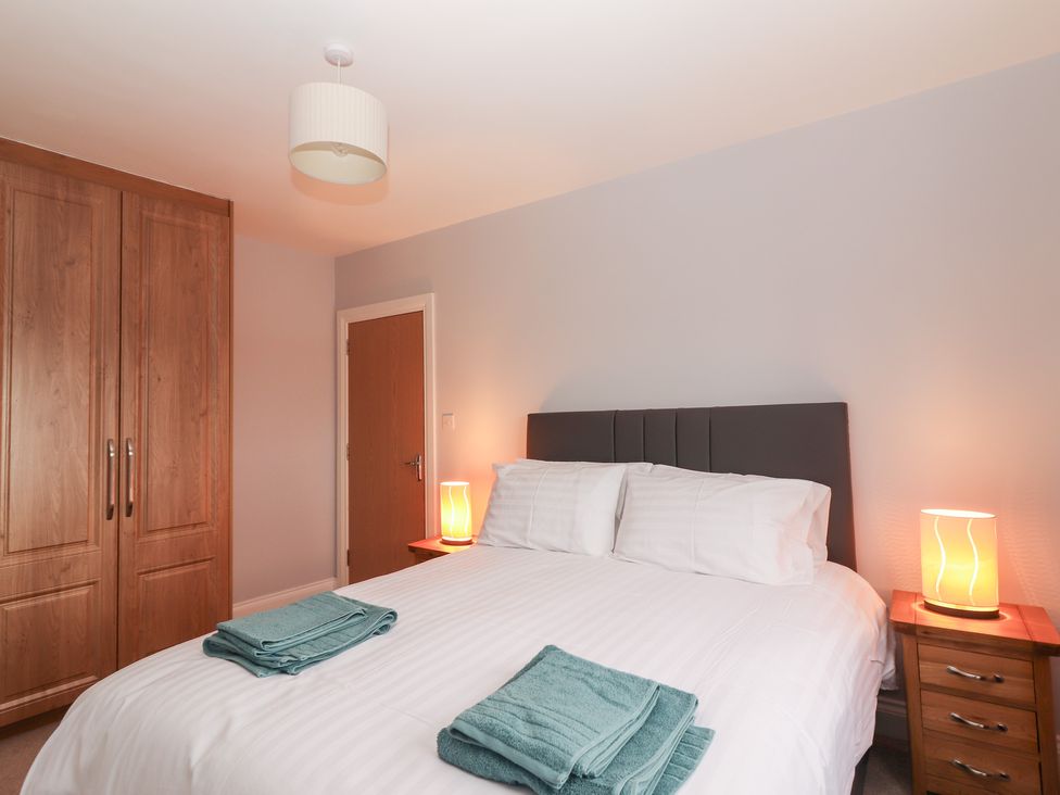 A bedroom with a bed and towels on it at 1 Windermere in Kinvarra