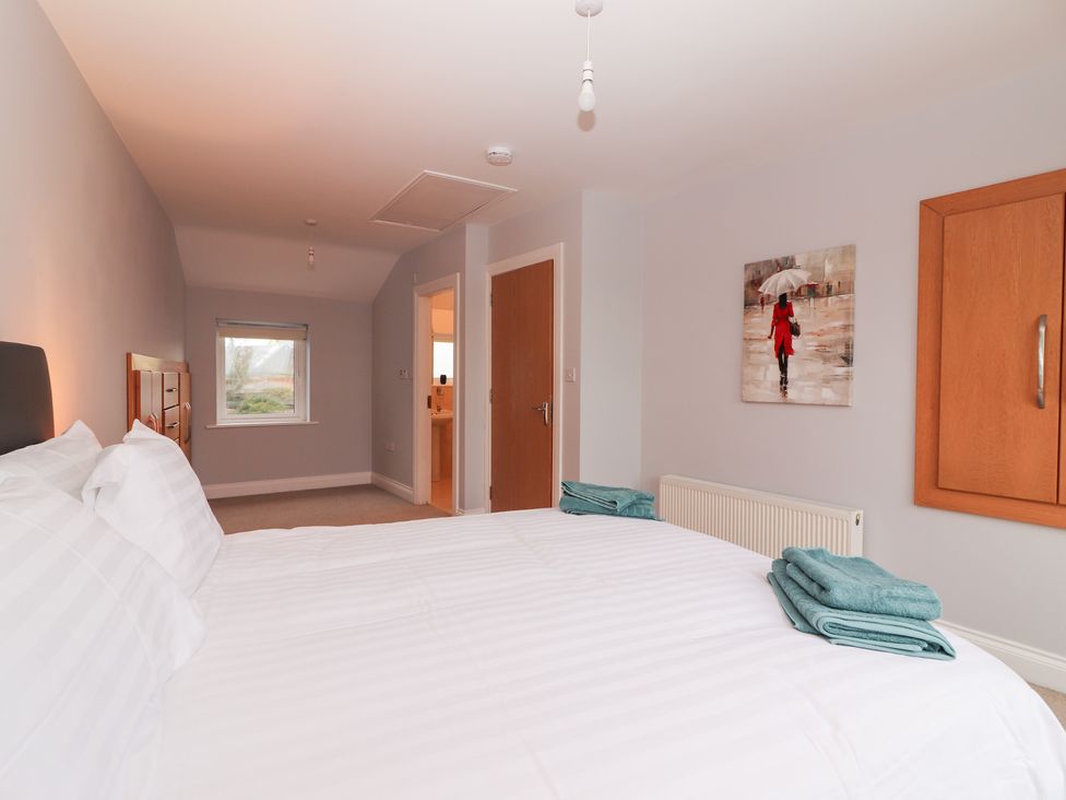 A bedroom with a bed and two towels at 1 Windermere in Kinvarra