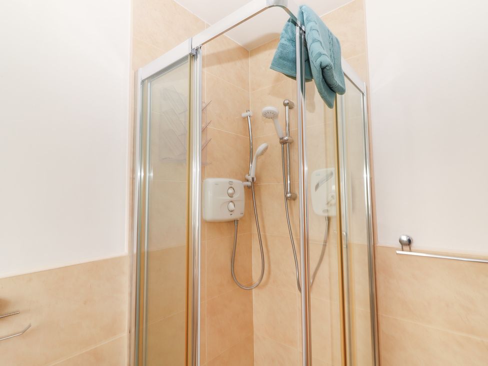 A shower with towel and water heater at 1 Windermere in Kinvarra