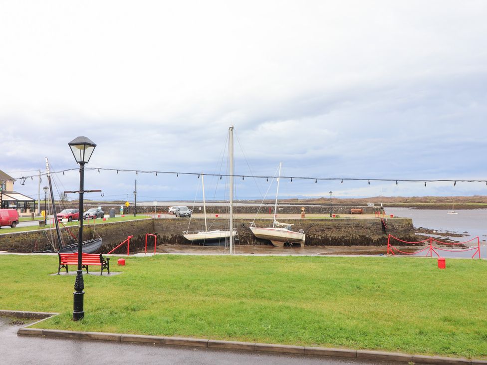 A waterfront view with boats and benches at 1 Windermere in Kinvarra