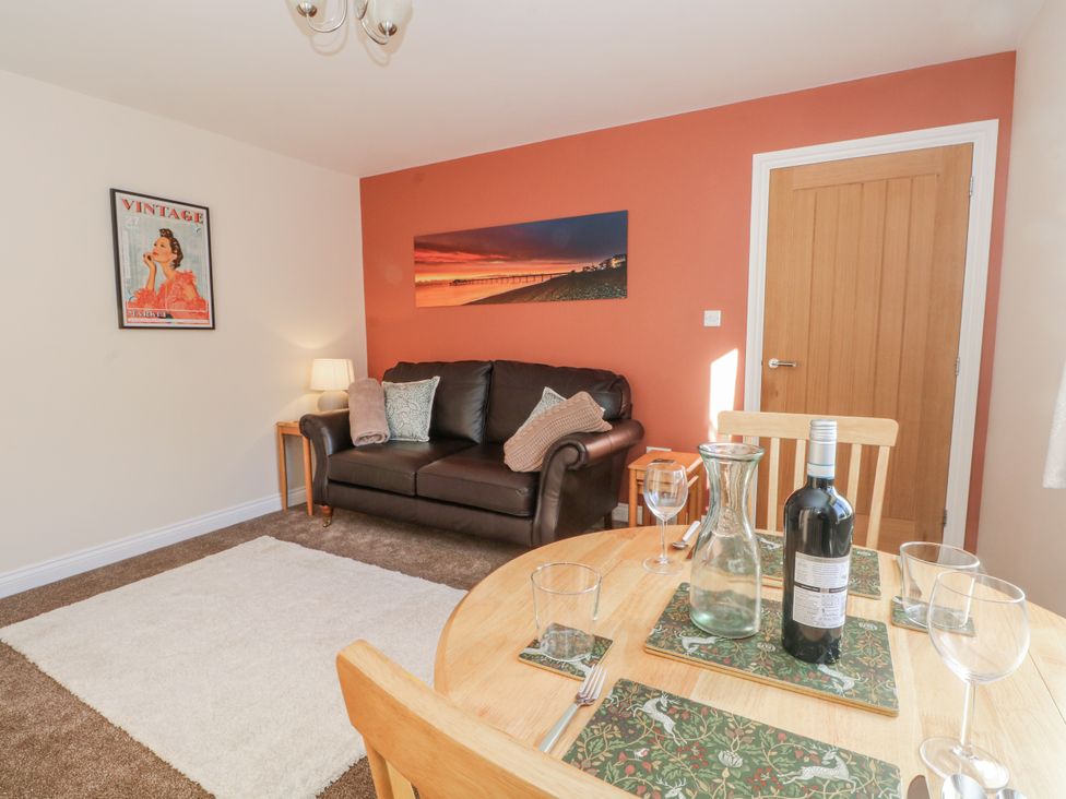 A living room with a sofa and dining table at The Annexe in Caverswall