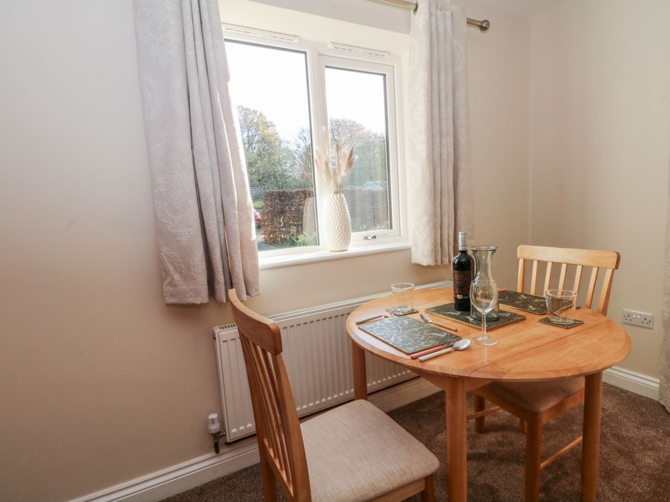 A dining room with a round table and chairs at The Annexe in Caverswall