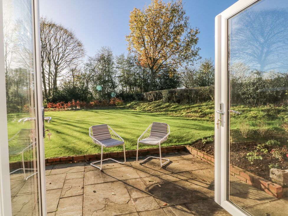 A garden with chairs and lawn at The Annexe Caverswall