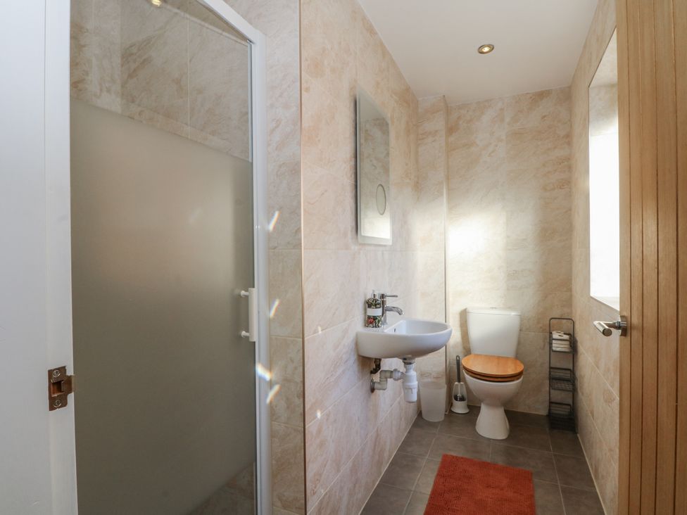 A bathroom with a shower, sink, and toilet at The Annexe in Caverswall