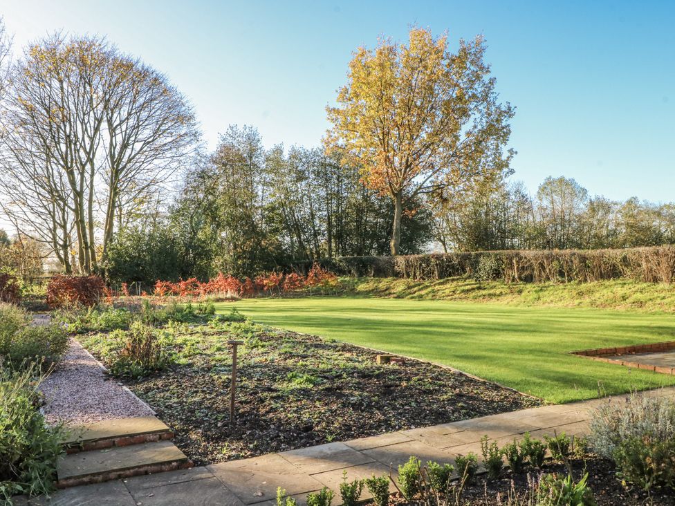 A garden with grass and trees at The Annexe Caverswall