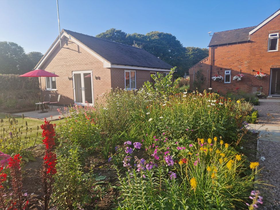 A house with a garden and patio table at The Annexe Caverswall