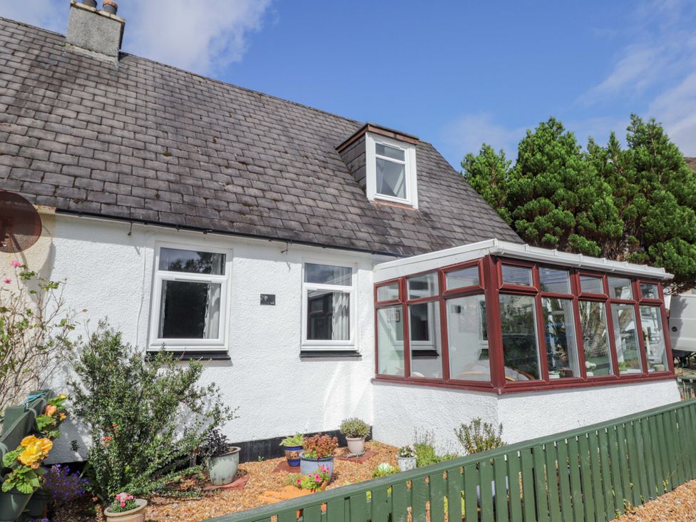 A house with a conservatory and plants in the garden at The Highlander in Dornie