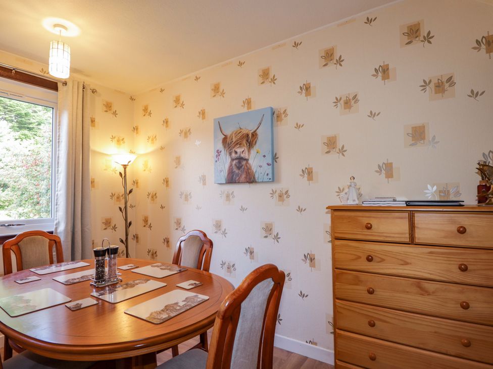 A dining room with a round table and chairs at The Highlander in Dornie