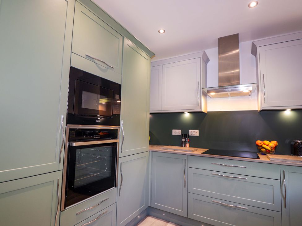 A kitchen with cabinets and appliances at The Highlander in Dornie