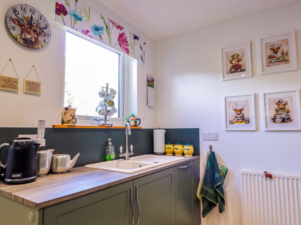A kitchen with a sink and wall decor at The Highlander in Dornie