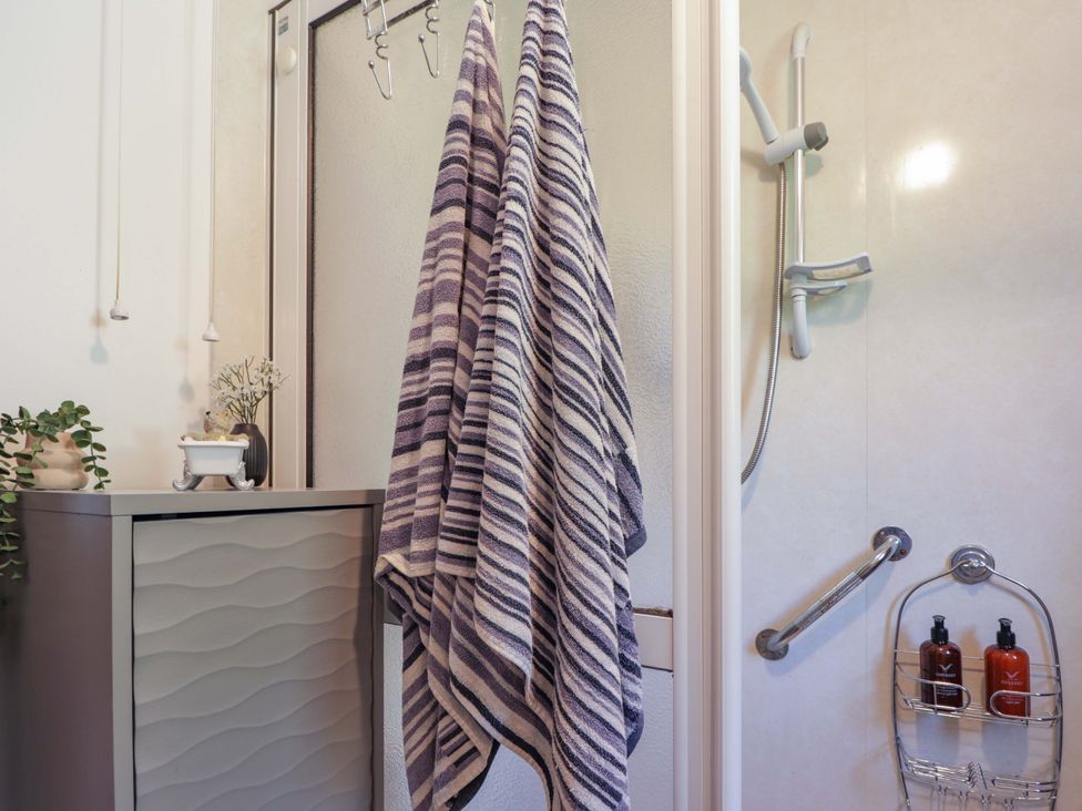 A bathroom with a shower and towels hanging at The Highlander in Dornie