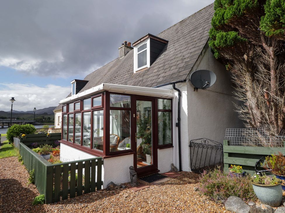 A house with a conservatory and garden at The Highlander in Dornie