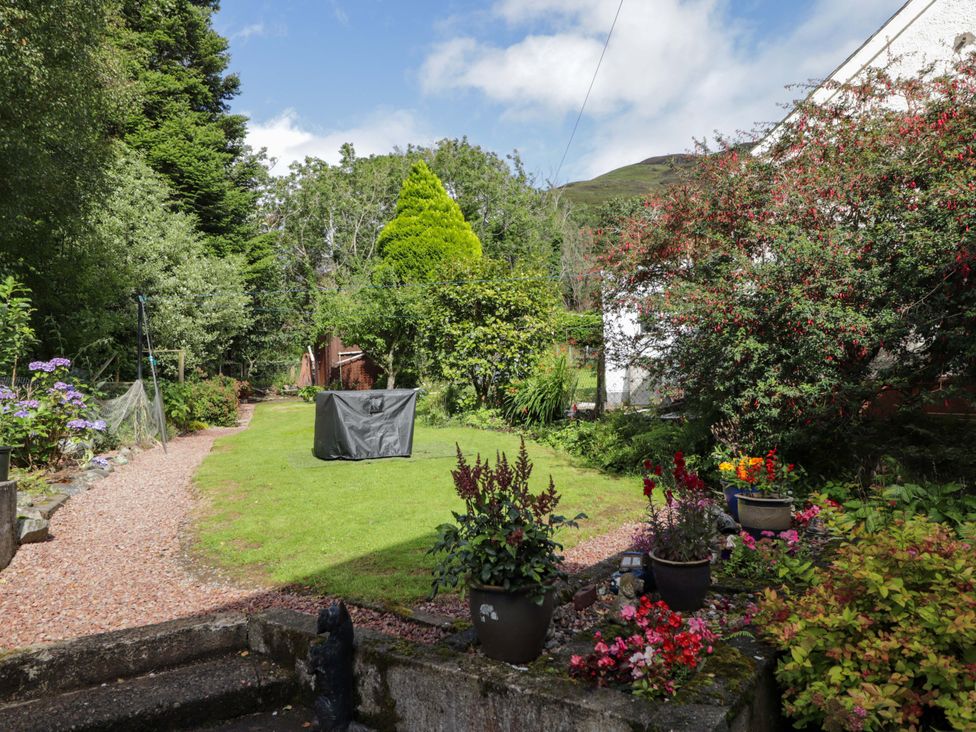 A garden with flowers and a pathway at The Highlander in Dornie
