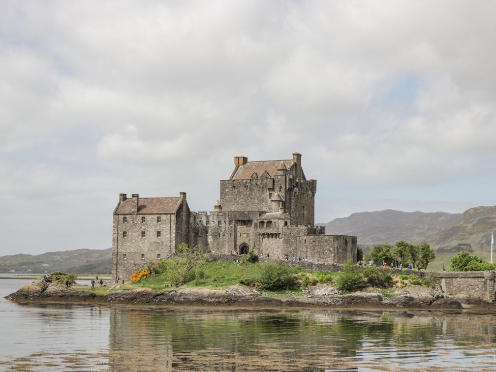 A castle on an island with water surrounding it at The Highlander in Dornie