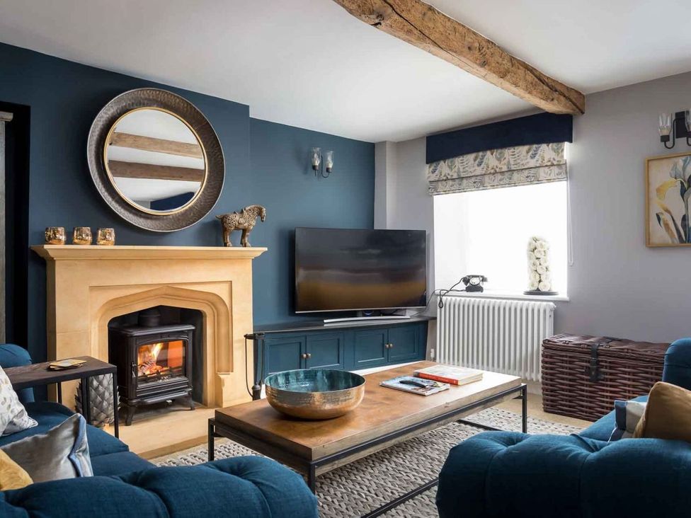 A living room with a fireplace and television at Lavender Cottage (Stow-on-the-Wold) Cheltenham