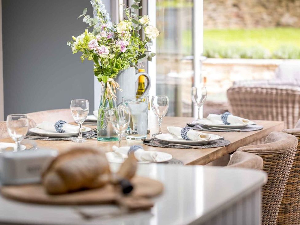 A dining room with a table set for dinner at Lavender Cottage (Stow-on-the-Wold) Cheltenham