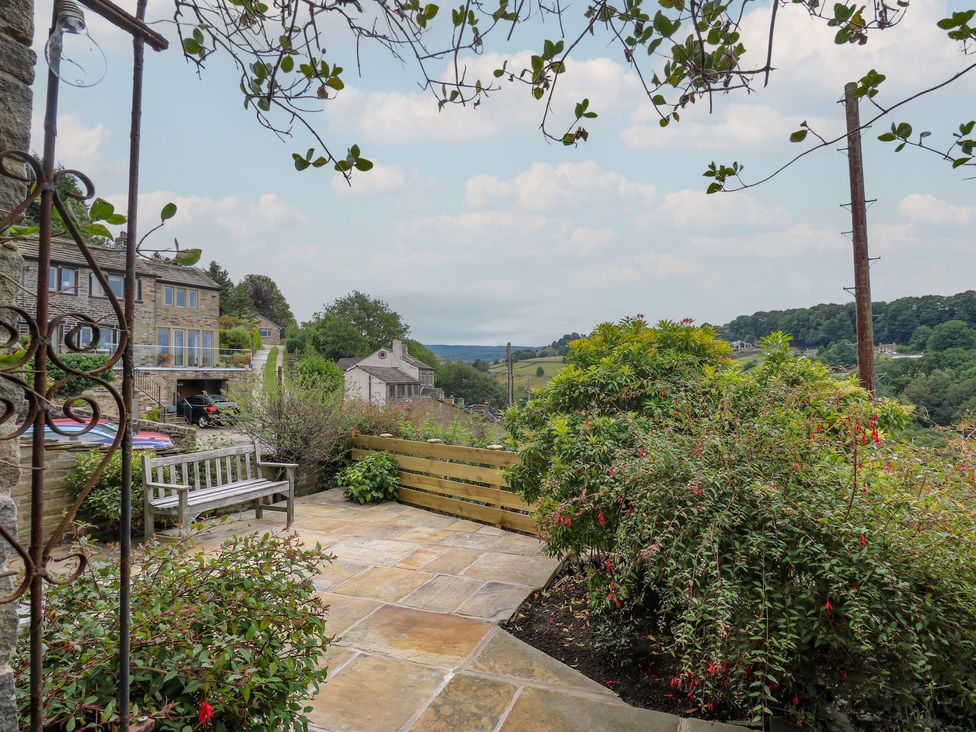 A patio with a bench and plants at 6 Well Hill in Holmfirth