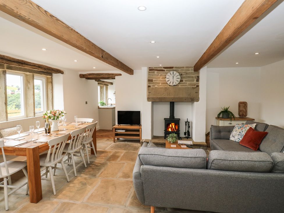 A living room with dining area and fireplace at 6 Well Hill in Holmfirth