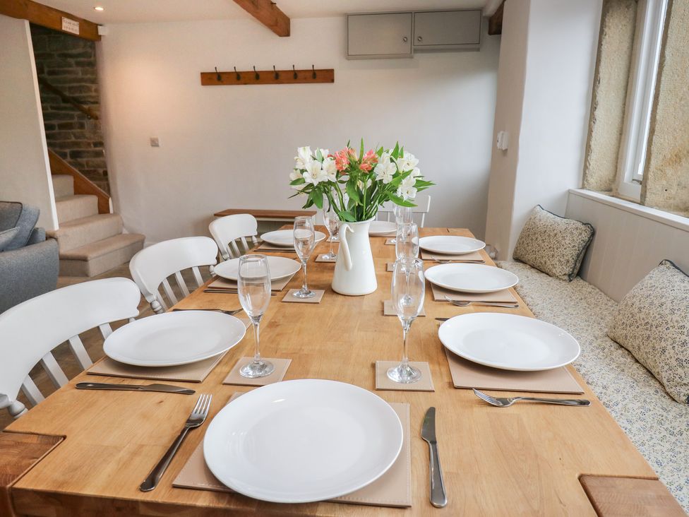 A dining room with a table set for a meal at 6 Well Hill in Holmfirth