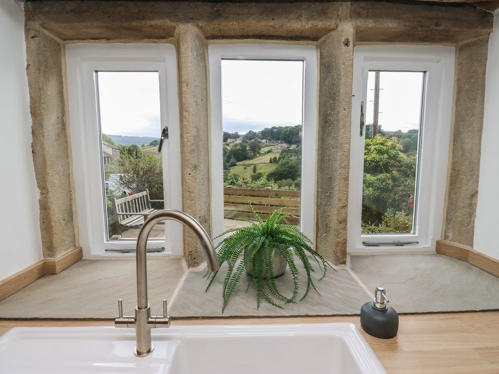 A kitchen window with a view and a plant at 6 Well Hill Holmfirth