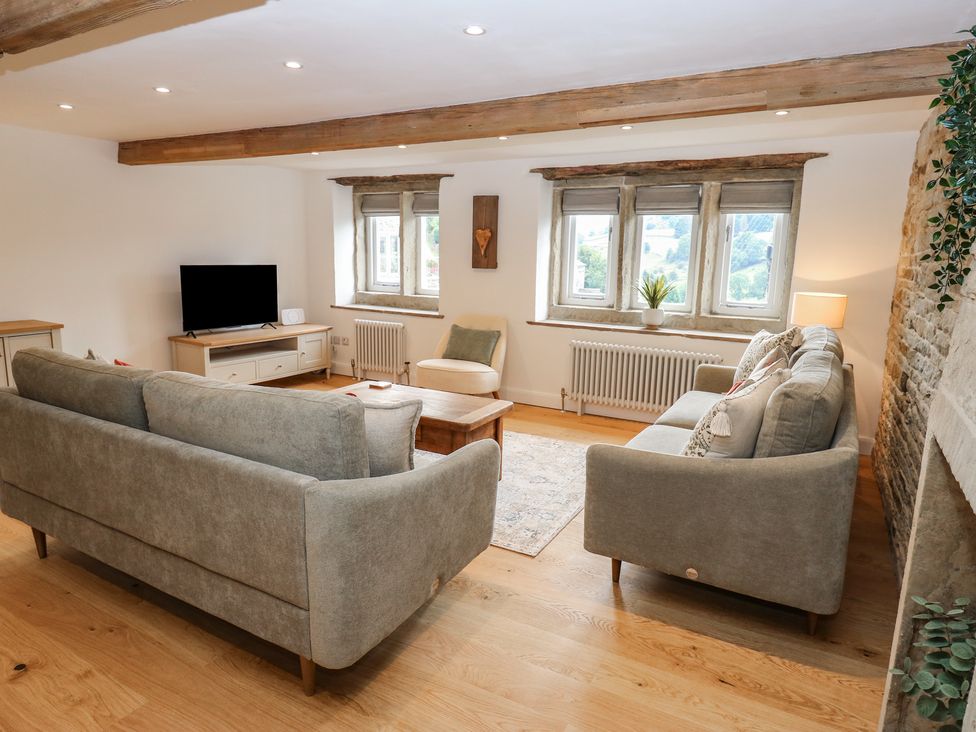 A living room with a sofa and television at 6 Well Hill Holmfirth