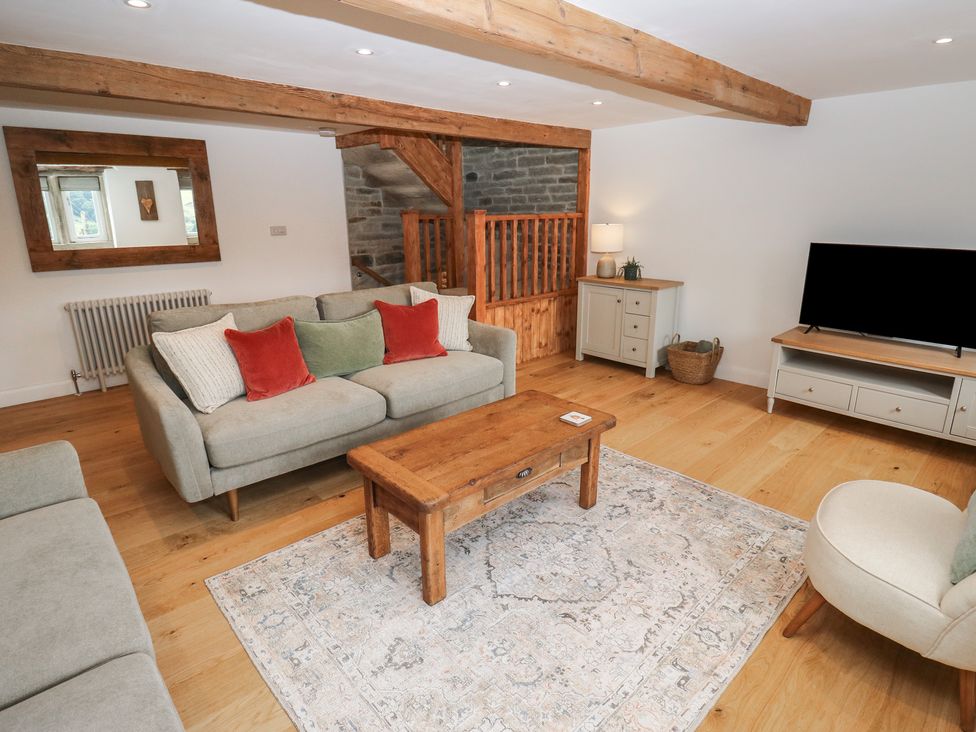 A living room with a sofa and coffee table at 6 Well Hill in Holmfirth