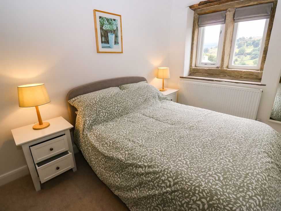 A bedroom with a bed and bedside lamps at 6 Well Hill in Holmfirth