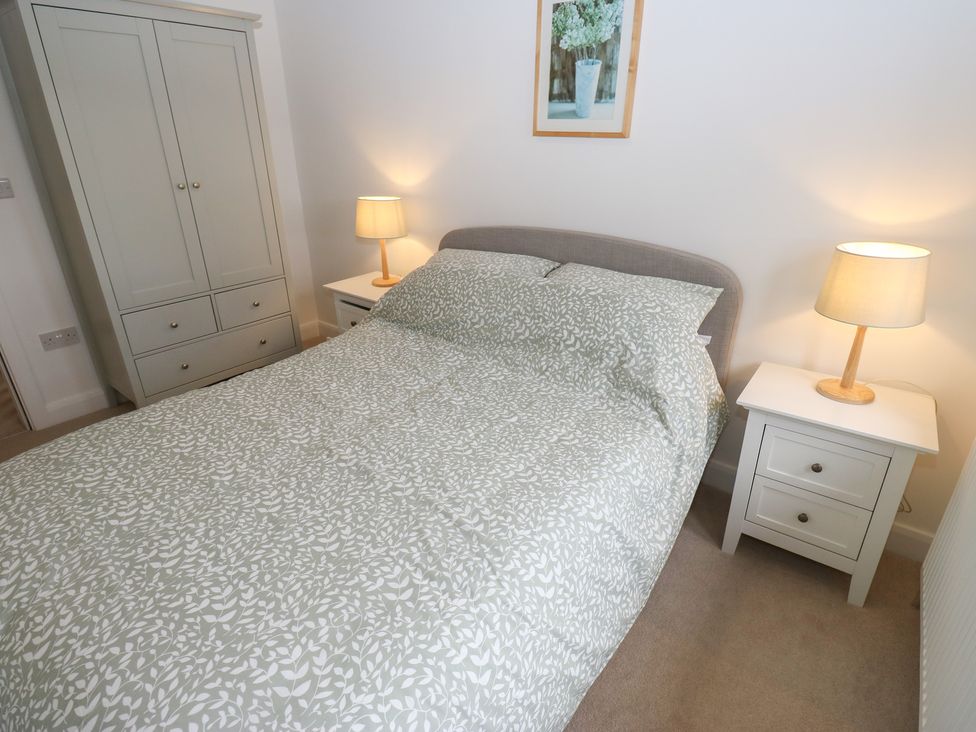 A bedroom with a bed, wardrobe, and nightstands at 6 Well Hill in Holmfirth