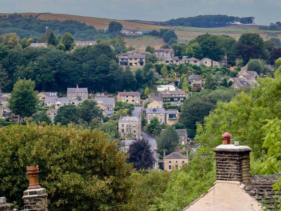 A view of a village with houses and trees at 6 Well Hill Holmfirth
