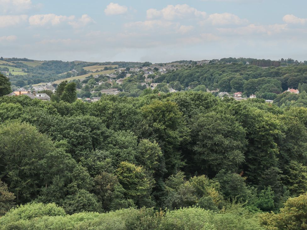 A landscape with trees and houses in the distance at 6 Well Hill Holmfirth