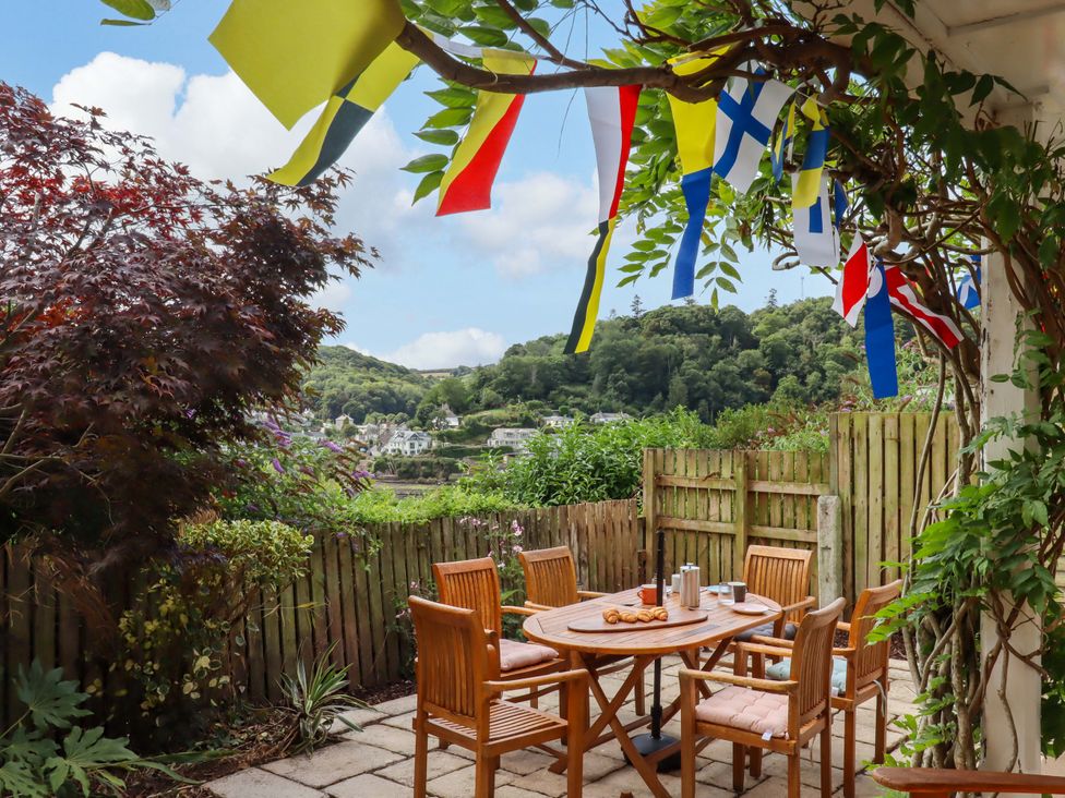 An outdoor seating area with a table and chairs at The Porthole in Newton Ferrers