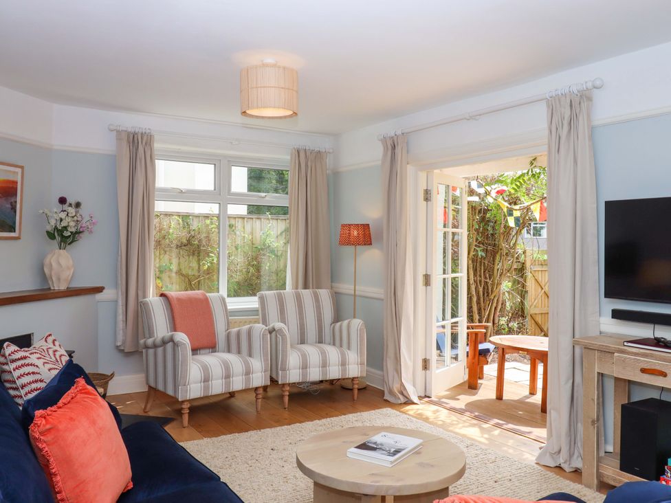 A living room with a sofa and armchairs at The Porthole in Newton Ferrers